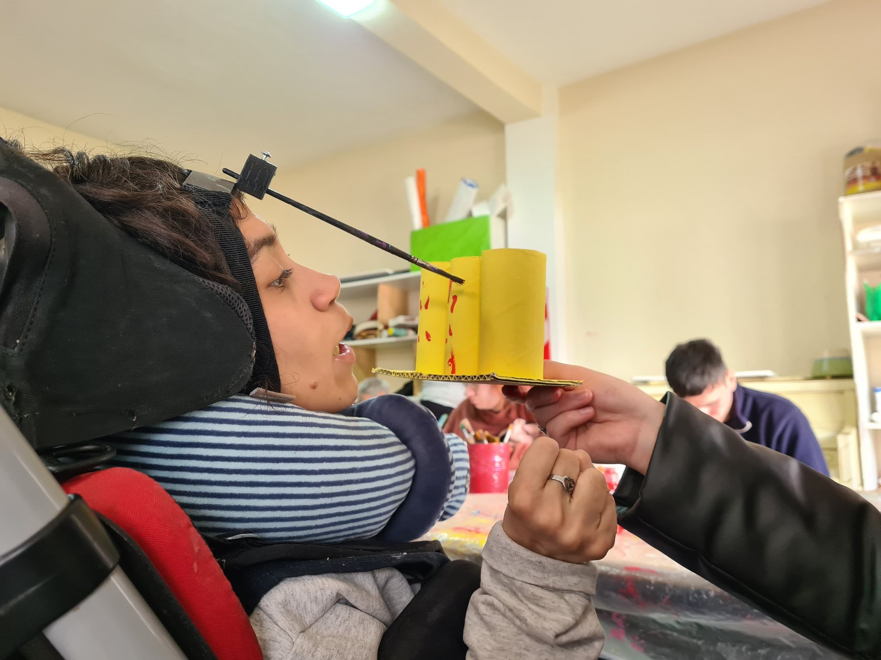 Una persona en silla de ruedas trabajando en un puesto adaptado del taller.