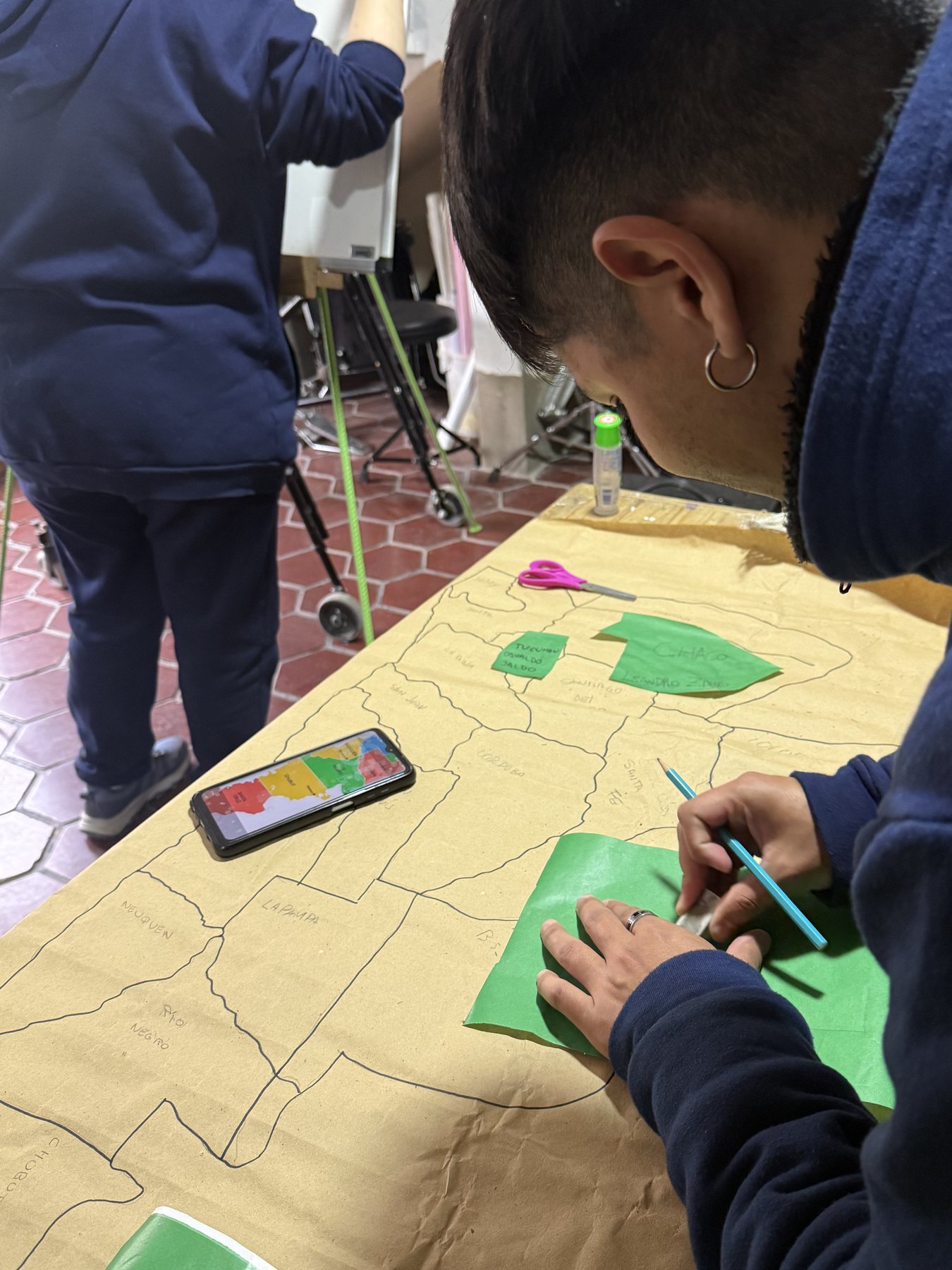 Mesa del taller de arte y reciclado con recortes de papel de colores.